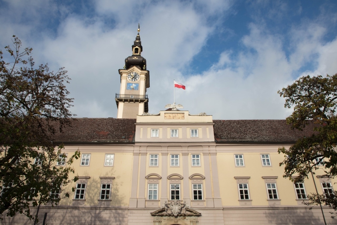 Large beige building with clock tower and Austrian flag